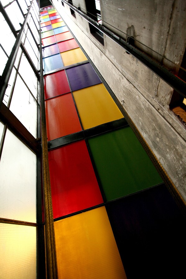 Una escalera con paneles de vidrio de colores y barandillas de metal.