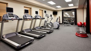 Ett gym med löpband, crosstrainers och en viktbänk.