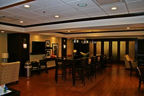 Enjoy communal dining and relaxation in this stylish room with a long dining table, comfortable seating area, and decorative touches.