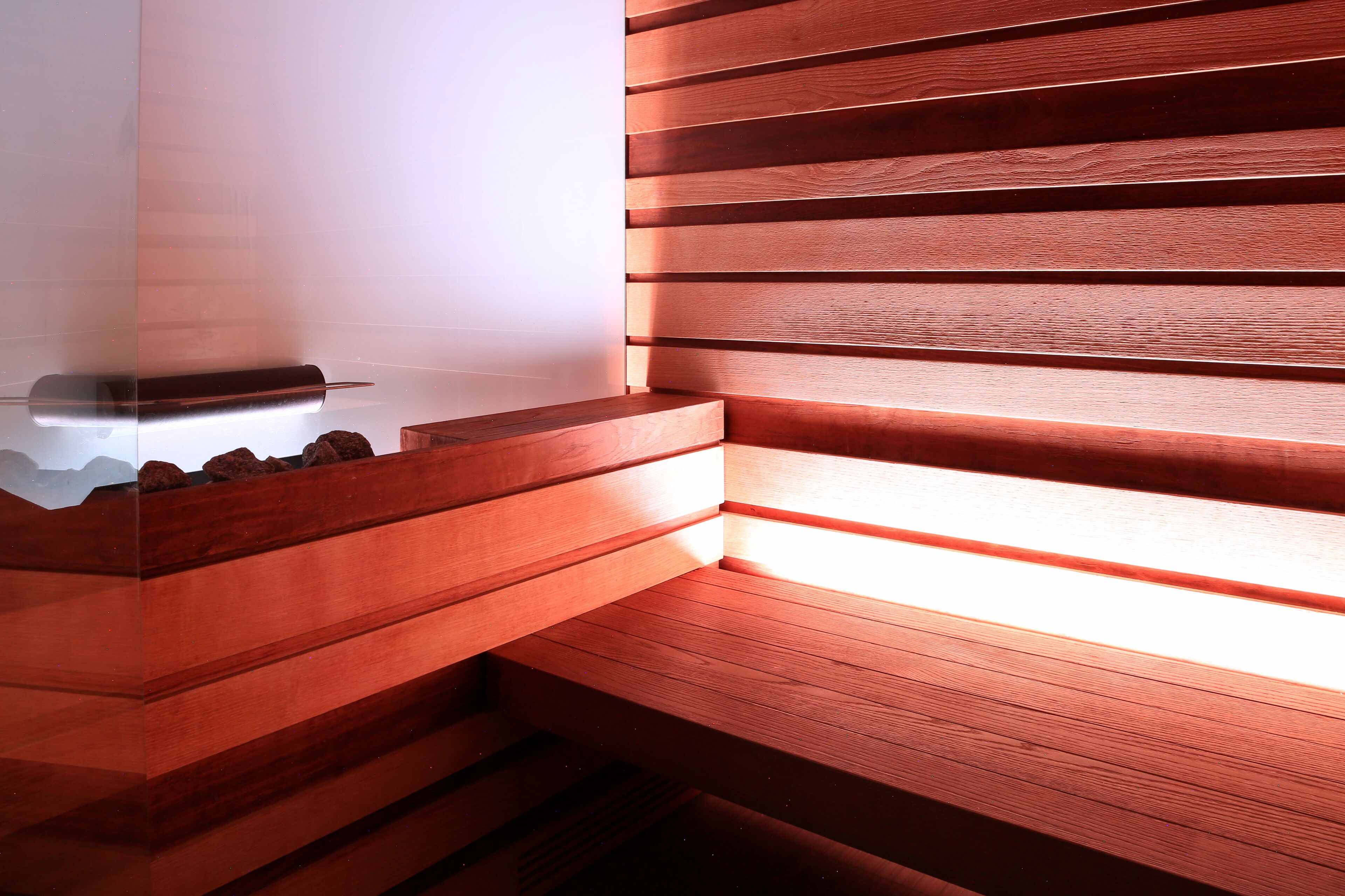 A corner of a room with wooden slats and a glass table.