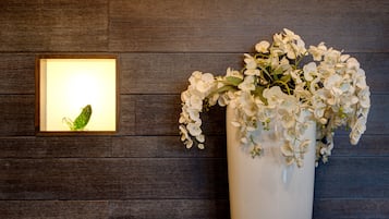Pared de madeira com um quadro emoldurado e um vaso de flores brancas.