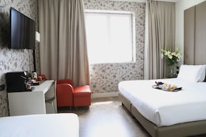 A hotel room with a bed, a desk with a coffee maker, a TV, and a window with curtains. - Klima Hotel Milano Fiere (Milan)