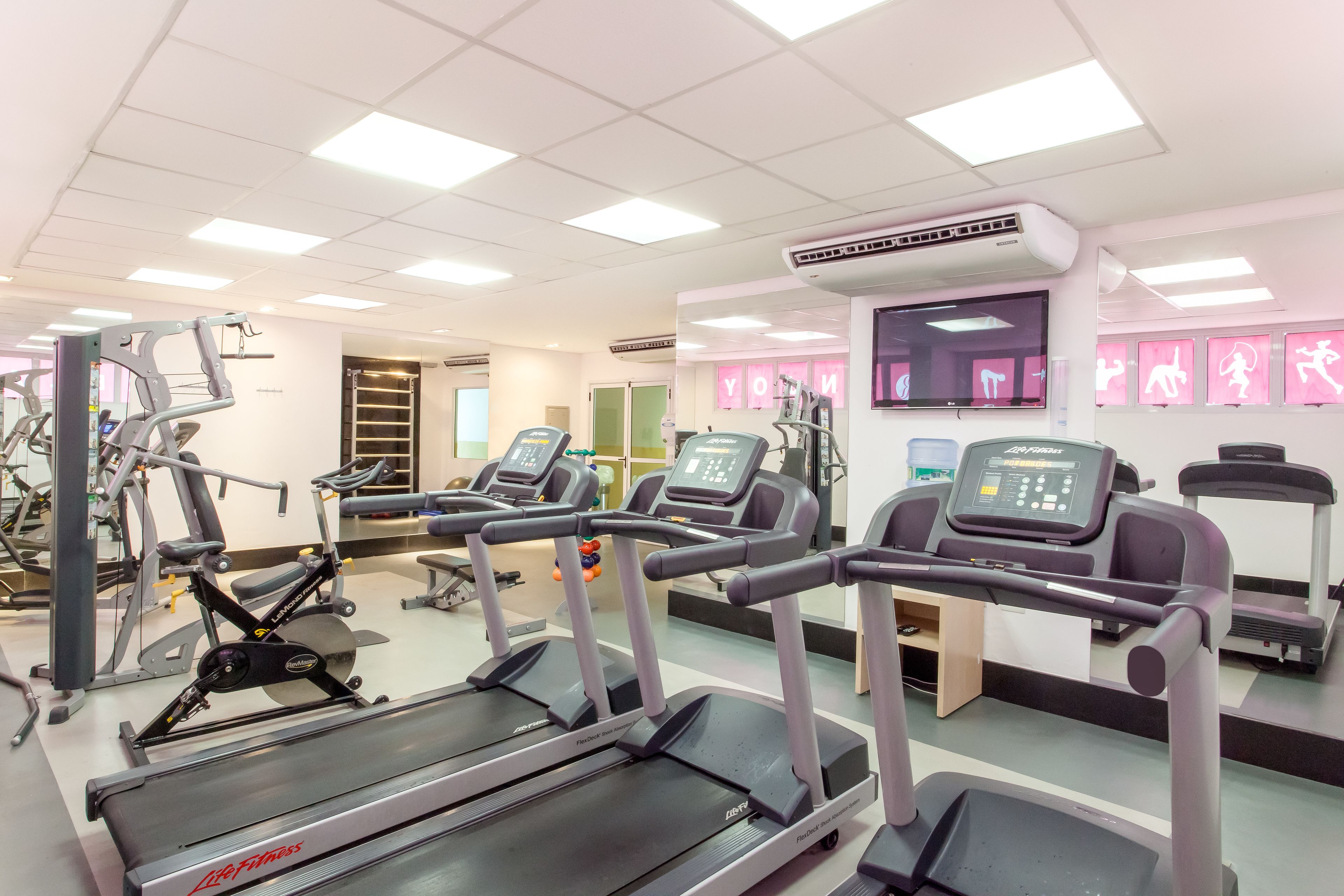 A gym with treadmills, exercise bikes, and weight machines.