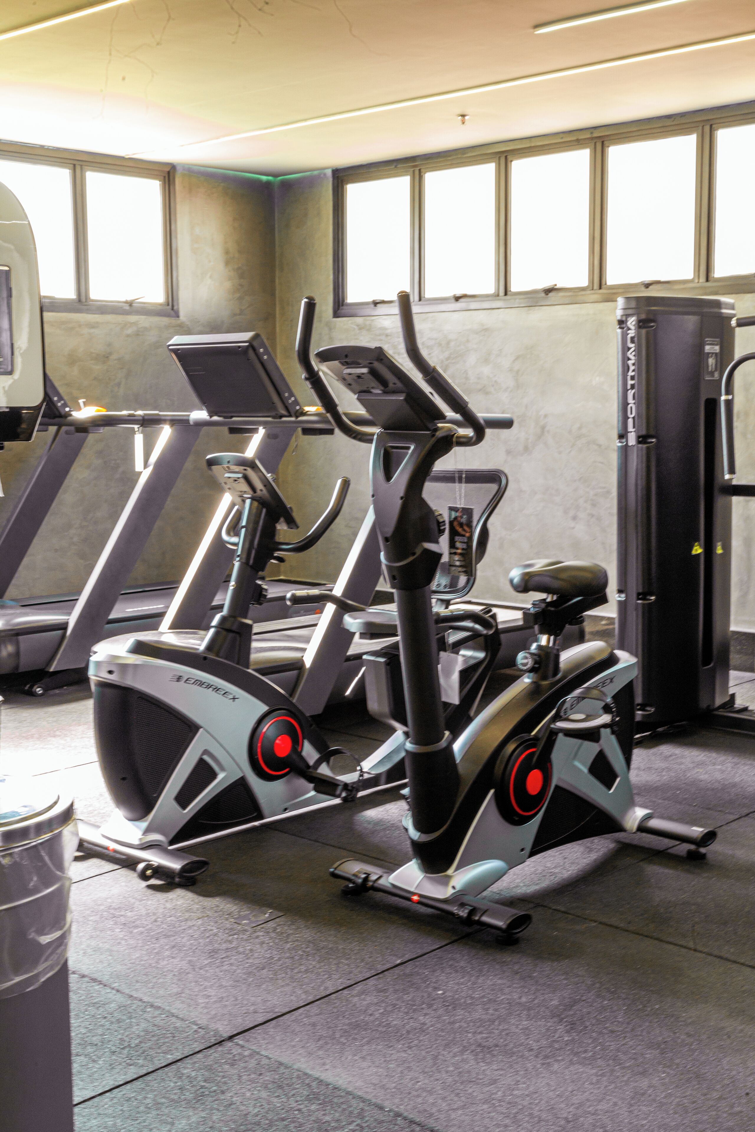 A gym with stationary bikes, a treadmill, and a weight machine.