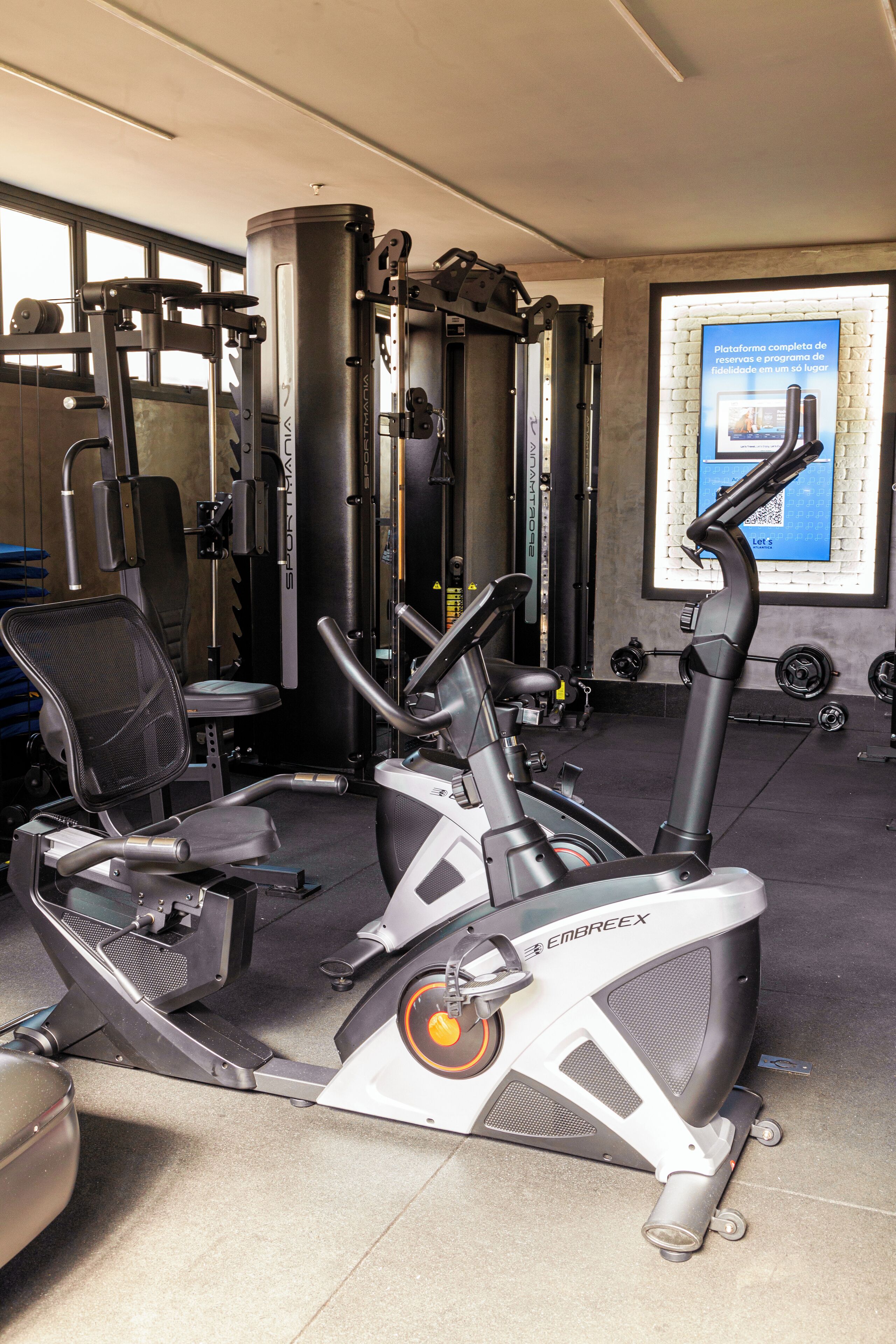 Un gimnasio con equipo de ejercicio, incluyendo una bicicleta estática y máquinas de pesas.