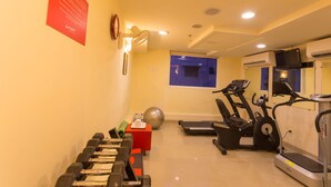 A gym with dumbbells, a red box, a ball, treadmills, and a stationary bike. - Ginger Chennai Vadapalani (Chennai)