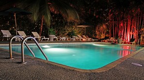 Una piscina al aire libre, sombrillas, tumbonas