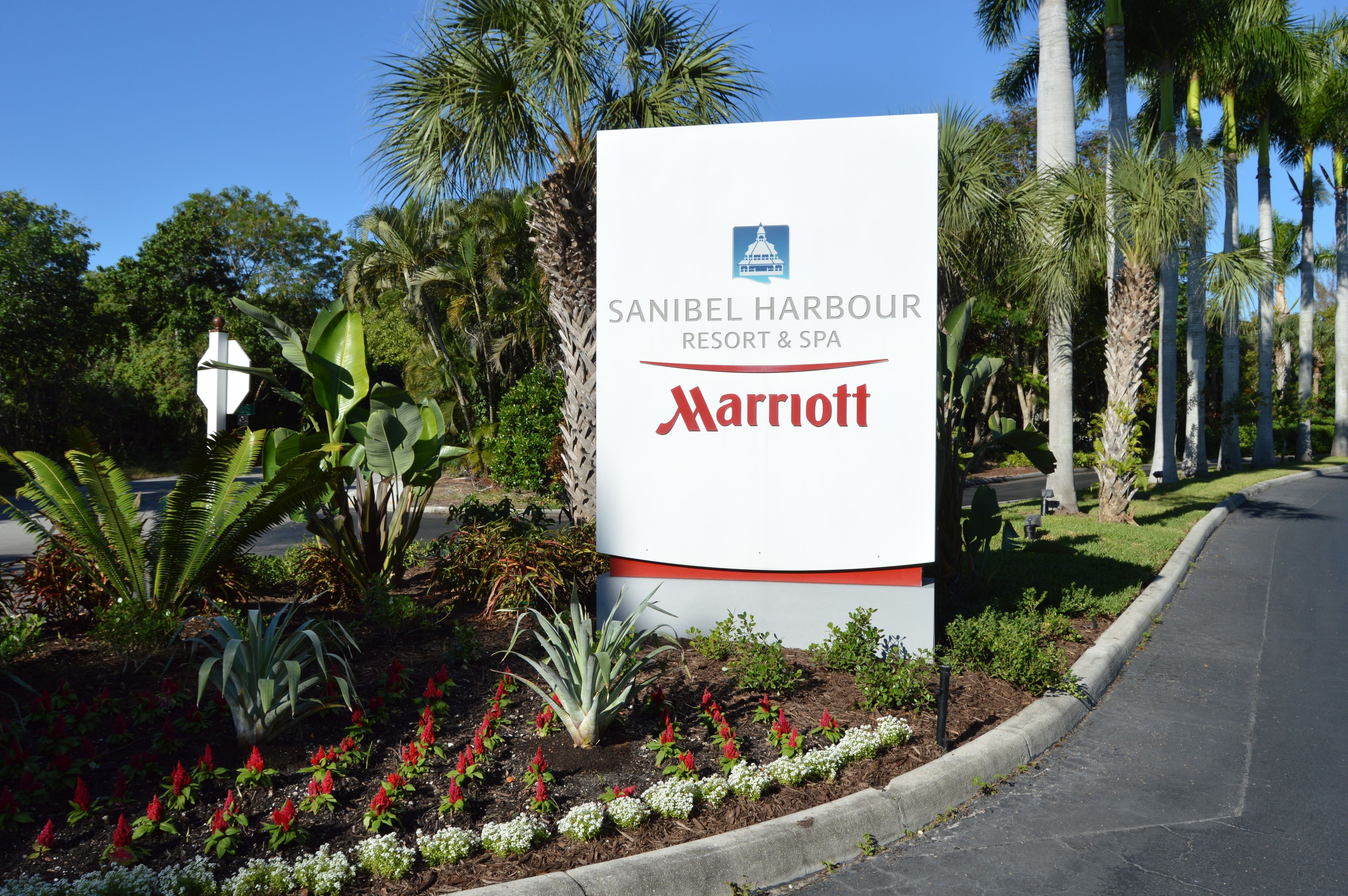 Señal del Sanibel Harbour Resort & Spa, Marriott, con jardín ajardinado y palmeras.
