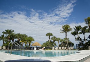 A swimming pool surrounded by palm trees and lounge chairs. - Resort Harbour Properties (Fort Myers)
