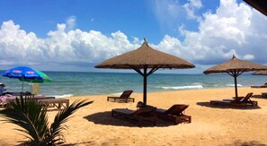 On the beach, white sand, sun-loungers, beach umbrellas
