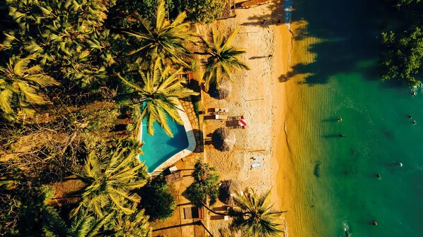 En la playa, sillas reclinables de playa, sombrillas, toallas de playa