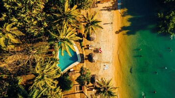 Rannalla, aurinkotuoleja, aurinkovarjoja, rantapyyhkeitä