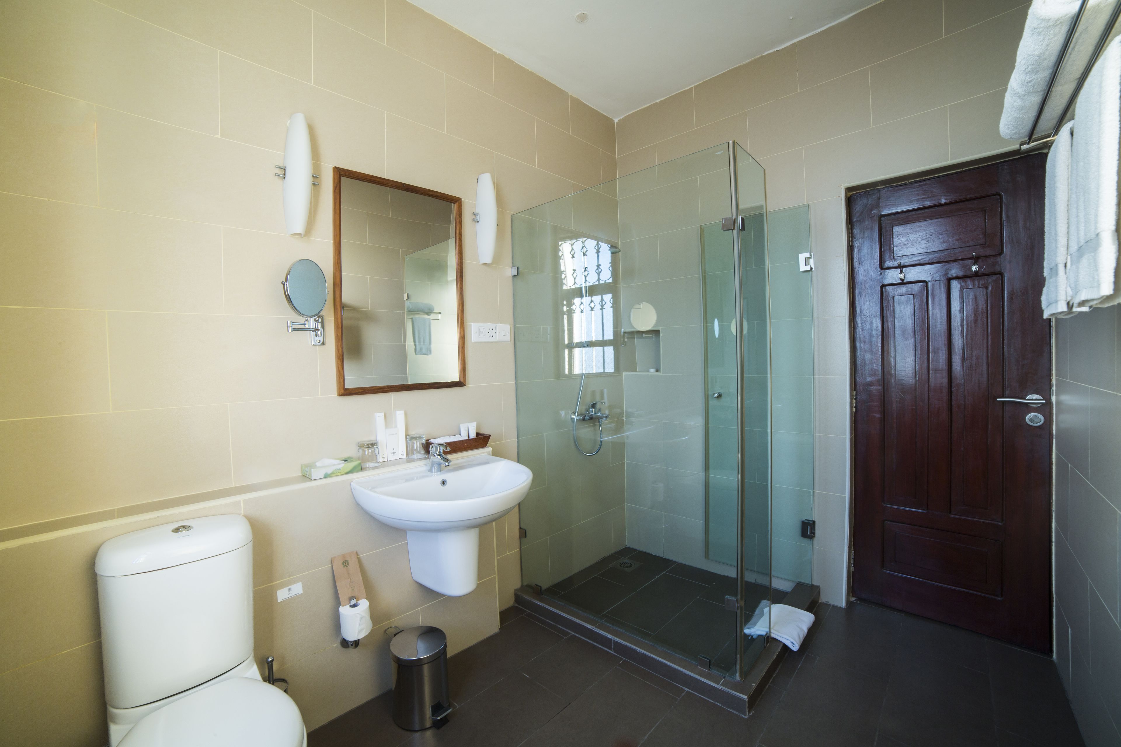 Un baño moderno con ducha de vidrio, lavamanos y inodoro.