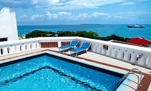 Piscine extérieure, parasols de plage, chaises longues