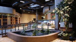 A spacious indoor atrium with a central water feature, surrounded by seating areas and a staircase. - Canad Inns Destination Centre Windsor Park (Winnipeg)