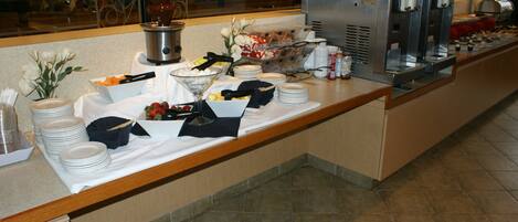 Una barra de buffet con diversos alimentos y utensilios.