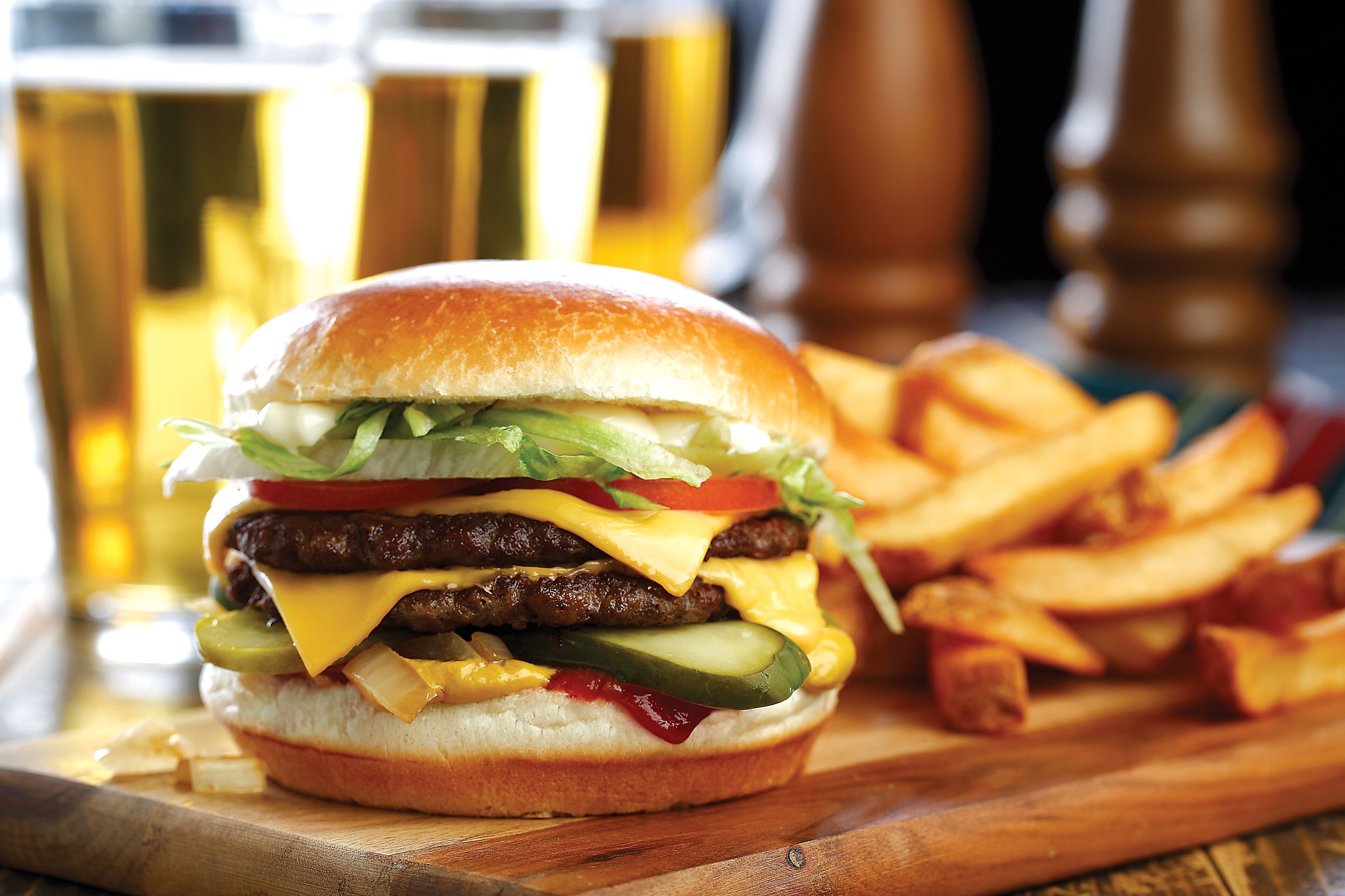 Una hamburguesa con papas fritas sobre una tabla de madera.