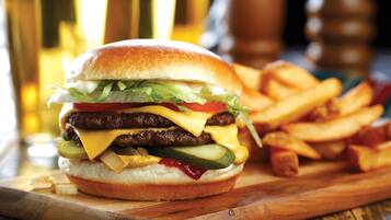 Una hamburguesa con papas fritas sobre una tabla de madera.