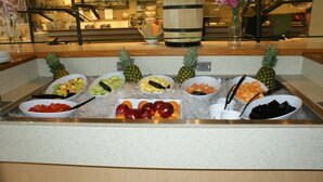 A buffet with various fruits and vegetables on ice, including apples, oranges, and pineapples. - Canad Inns Destination Centre Windsor Park (Winnipeg)