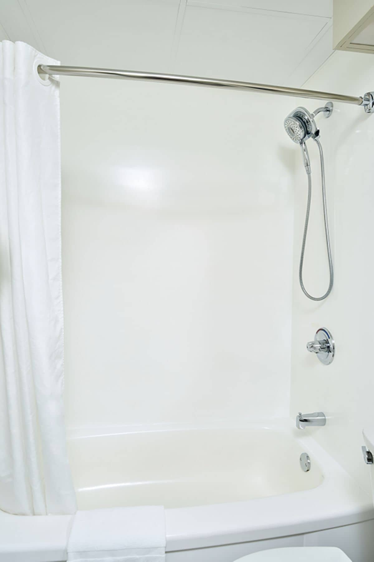 Eine weiße Badewanne mit Duschkopf und Wasserhahn.