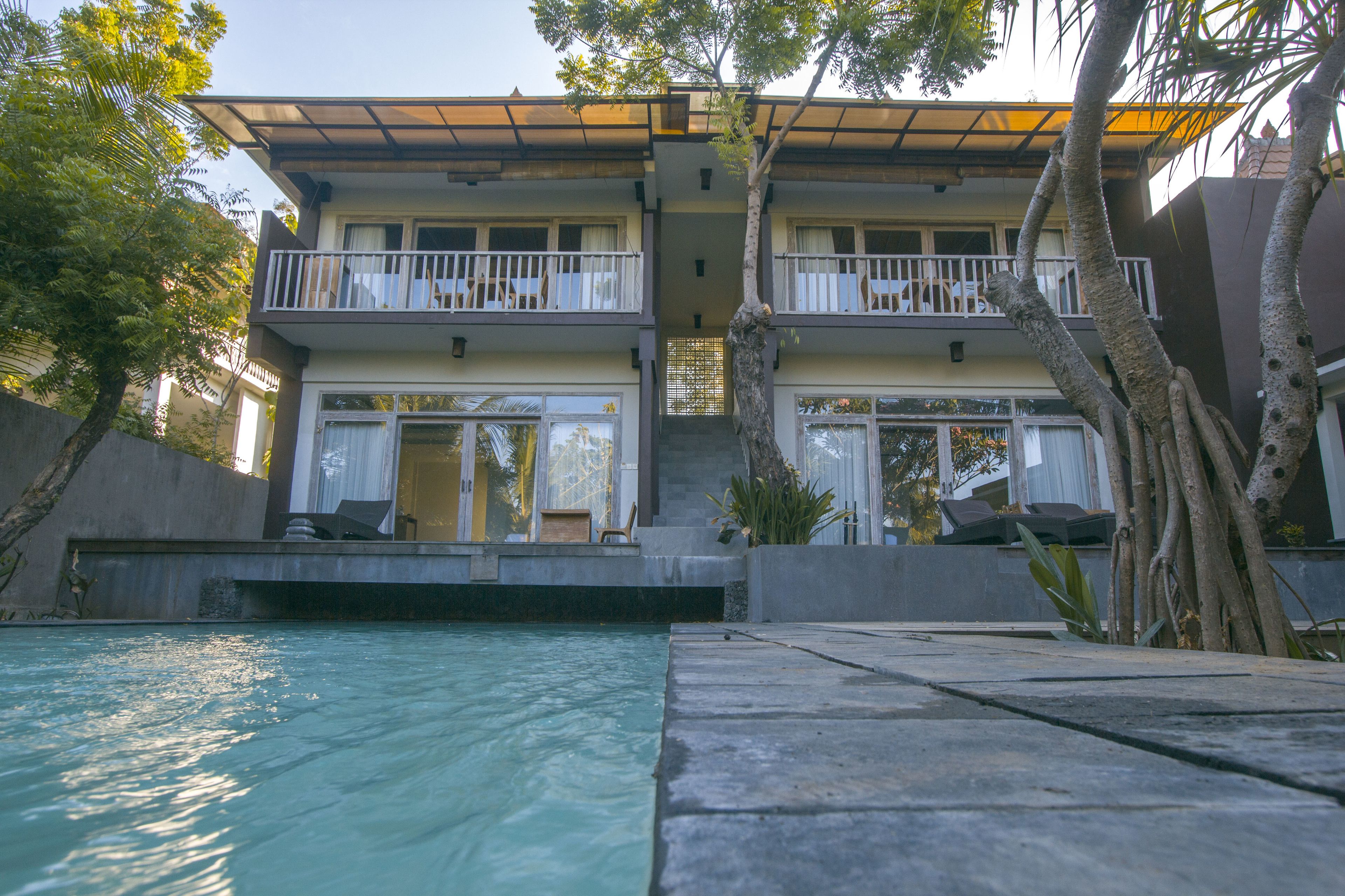 A two-story building with a swimming pool in the foreground.