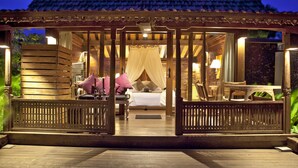 A wooden structure with a bed, pillows, and a bench. - KajaNe Tulamben (Kubu)