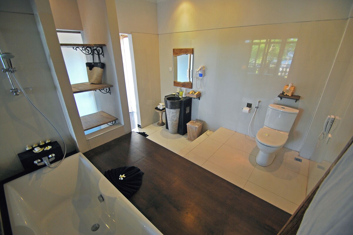 A modern bathroom with a bathtub, toilet, and sink.