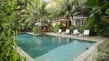 Una piscina al aire libre, camas de piscina gratis, sombrillas