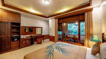 Una habitación de hotel con una cama grande, muebles de madera, televisión y vistas al exterior.
