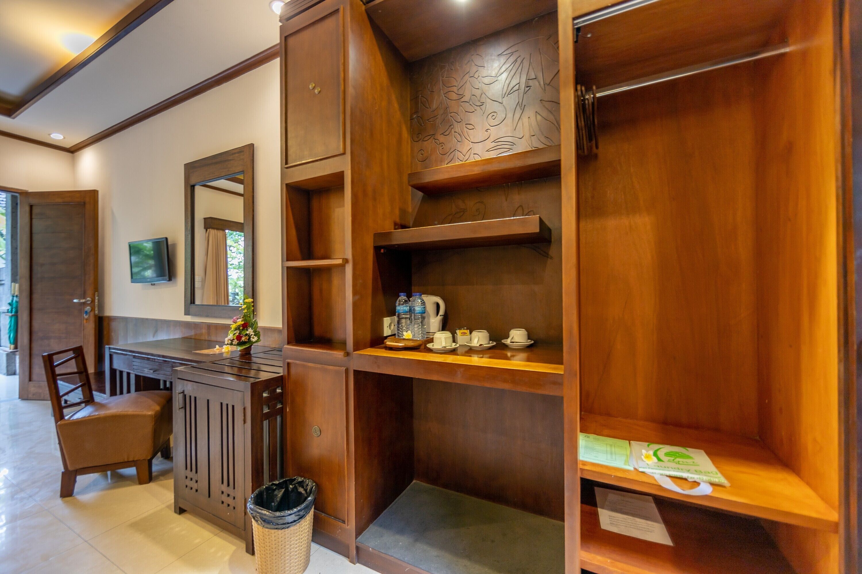 Un intérieur en bois comprenant un bureau, une chaise et des étagères où sont rangés divers objets, comme une bouilloire et des tasses.