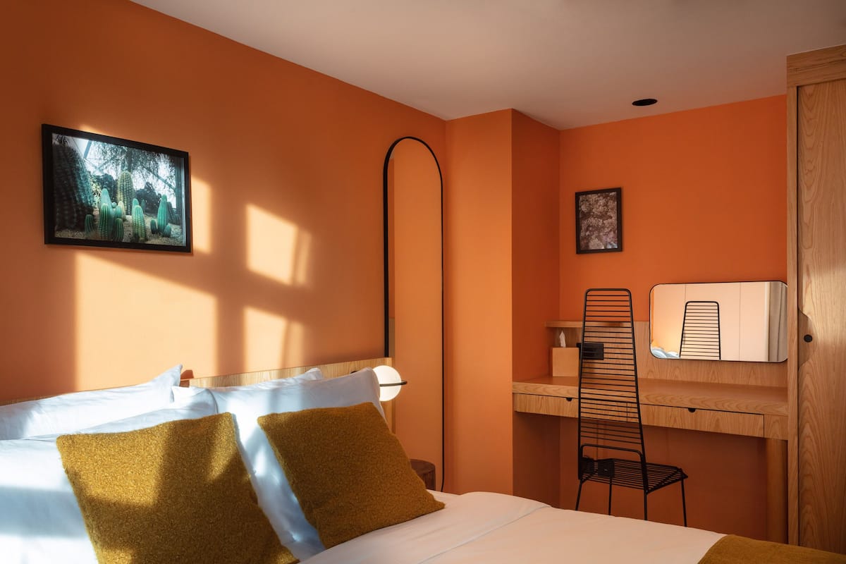 A hotel room with a bed, a desk, and a chair.