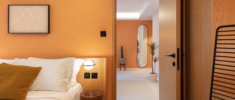 A hotel room with a bed, bedside table, and a wall-mounted artwork.