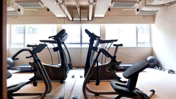 A gym with stationary bikes, a treadmill, and exercise balls.