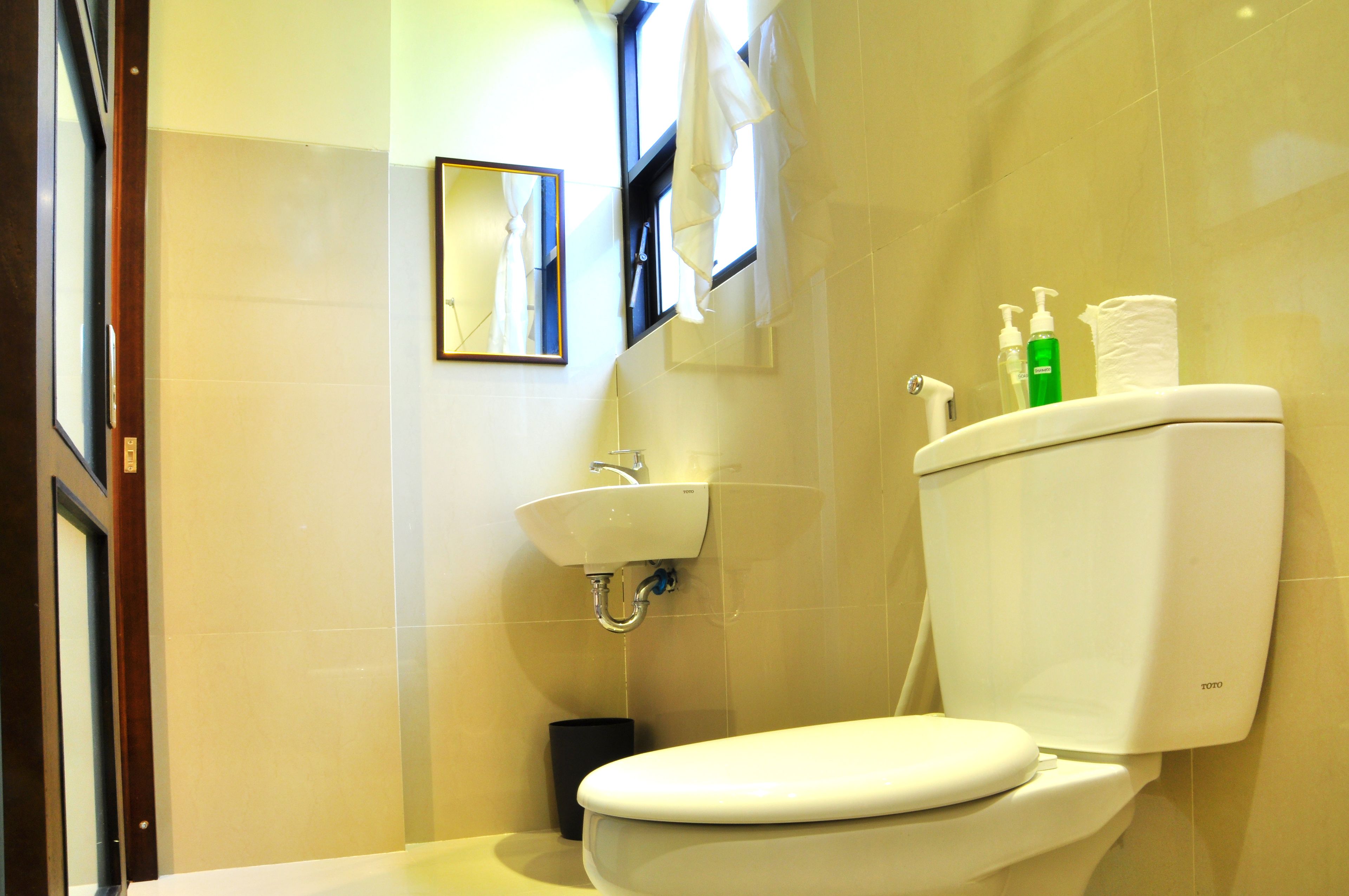 Un baño con inodoro, lavamanos y espejo.