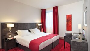 A hotel room with a large bed, two bedside tables, a desk, and a chair. - Appart'City Confort Grenoble Inovallée (Montbonnot-Saint-Martin)