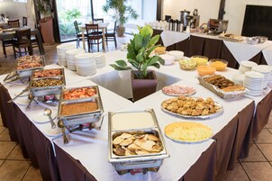 Een buffet met diverse gerechten en een bloempot in het midden.