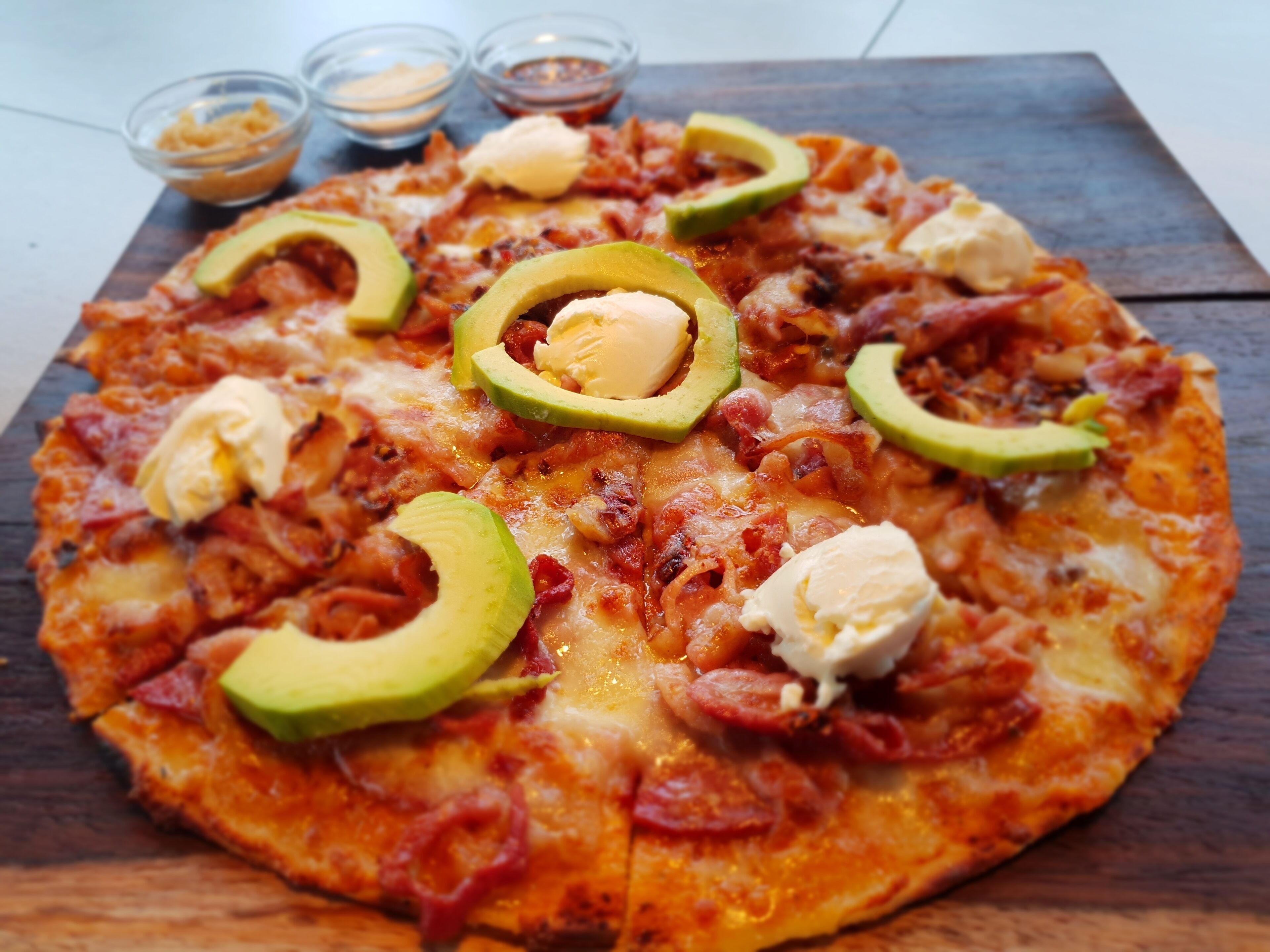 A pizza with toppings on a wooden board.