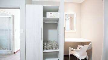 Un baño moderno con tocador blanco, perchero y zona de ducha.