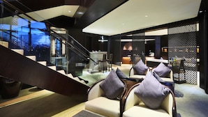 Un interior moderno con una escalera, una zona de estar y un mostrador de recepción.