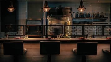 A modern kitchen with a brick backsplash, stainless steel appliances, and pendant lighting.