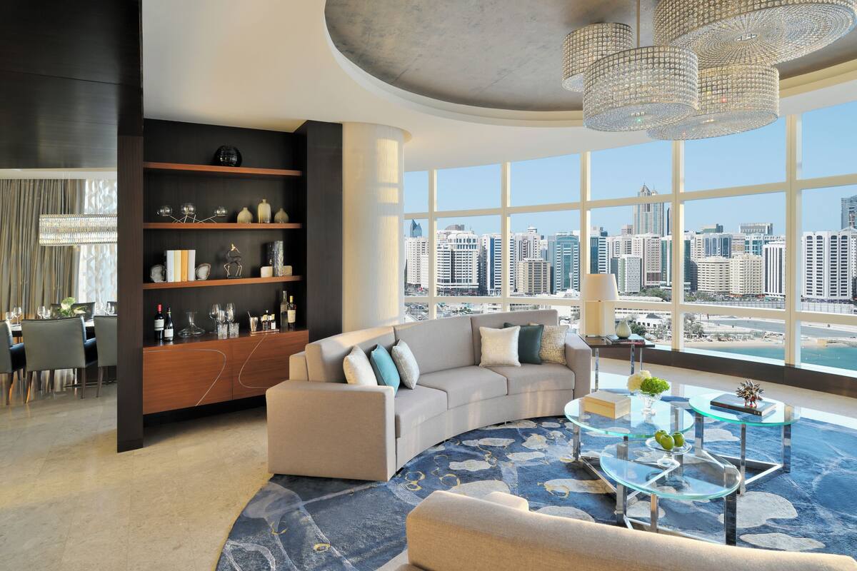 Un salon moderne avec une grande fenêtre, un canapé, une table basse et une bibliothèque.
