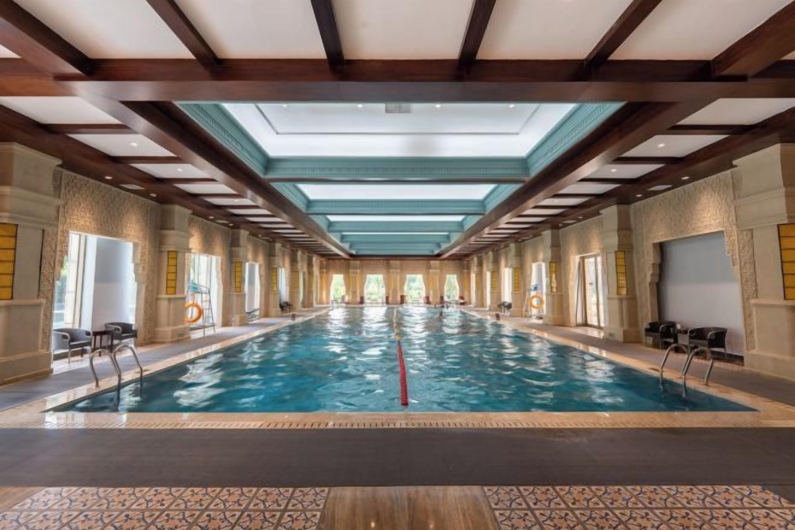 A large indoor swimming pool with a vaulted ceiling and a long, narrow layout.