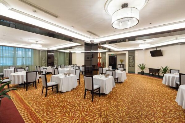 A conference room with round tables, chairs, and a carpeted floor. - Inspirock Hotel (Jiaxing)