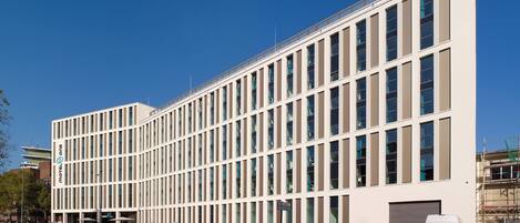 Un edificio moderno con facciata simmetrica, numerose finestre e tetto piano.