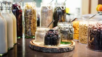 Diversi prodotti alimentari in vasetti di vetro su un tagliere di legno.