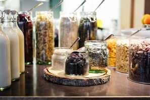 A variety of food items in glass jars on a wooden board.