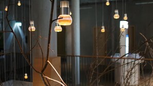 Un interior moderno con pilares de concreto expuesto, lámparas colgantes y una recepción visible.