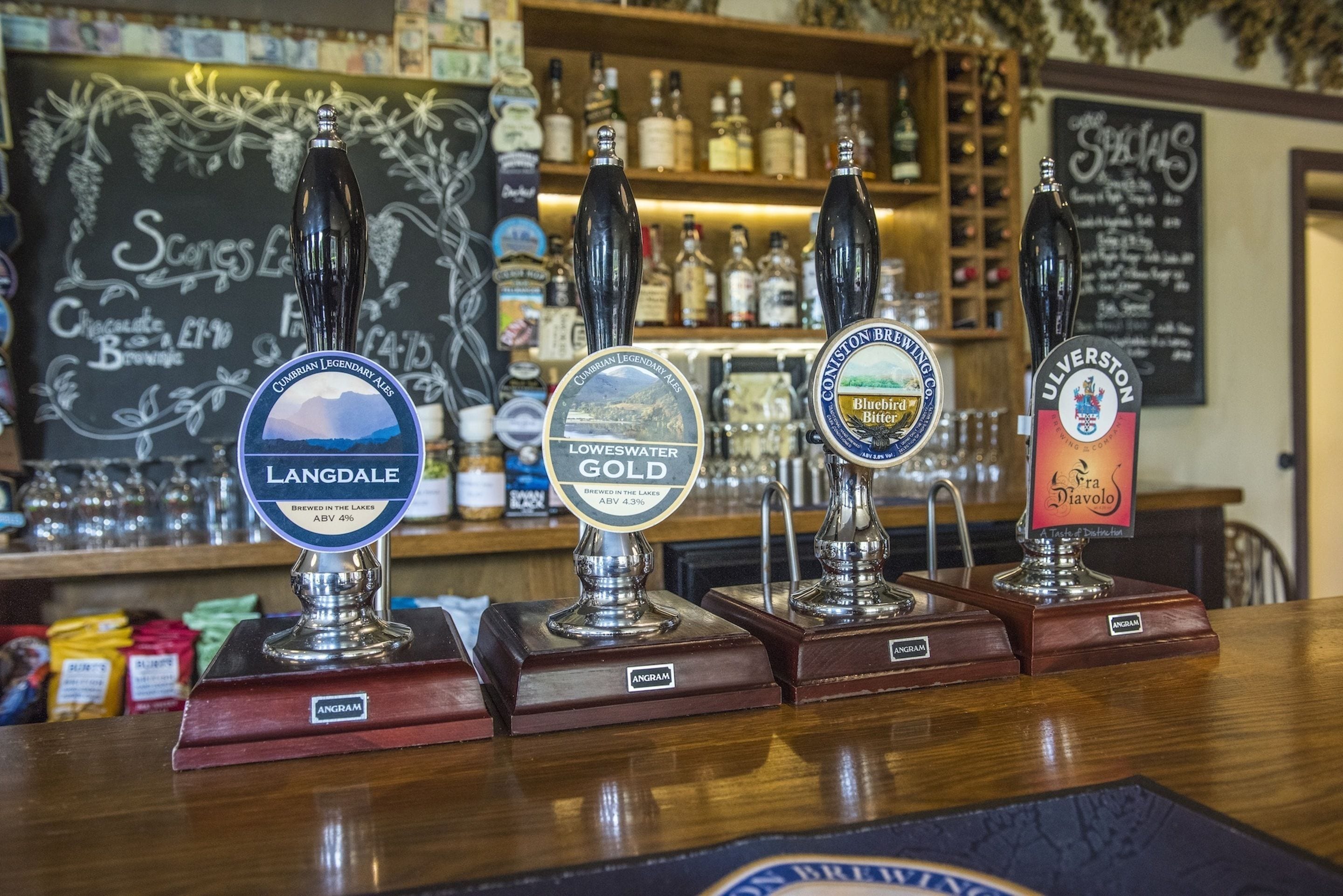 A bar with four taps labeled Langdale, Loweswater Gold, Consetton Brewery Bluebird, and Ulverston.