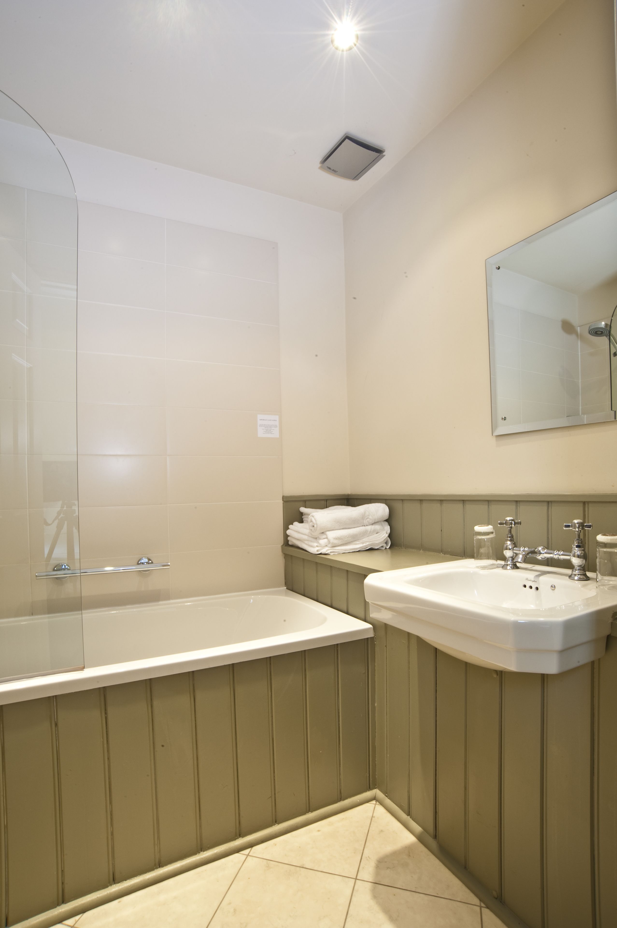 Un baño con bañera, lavamanos y espejo.