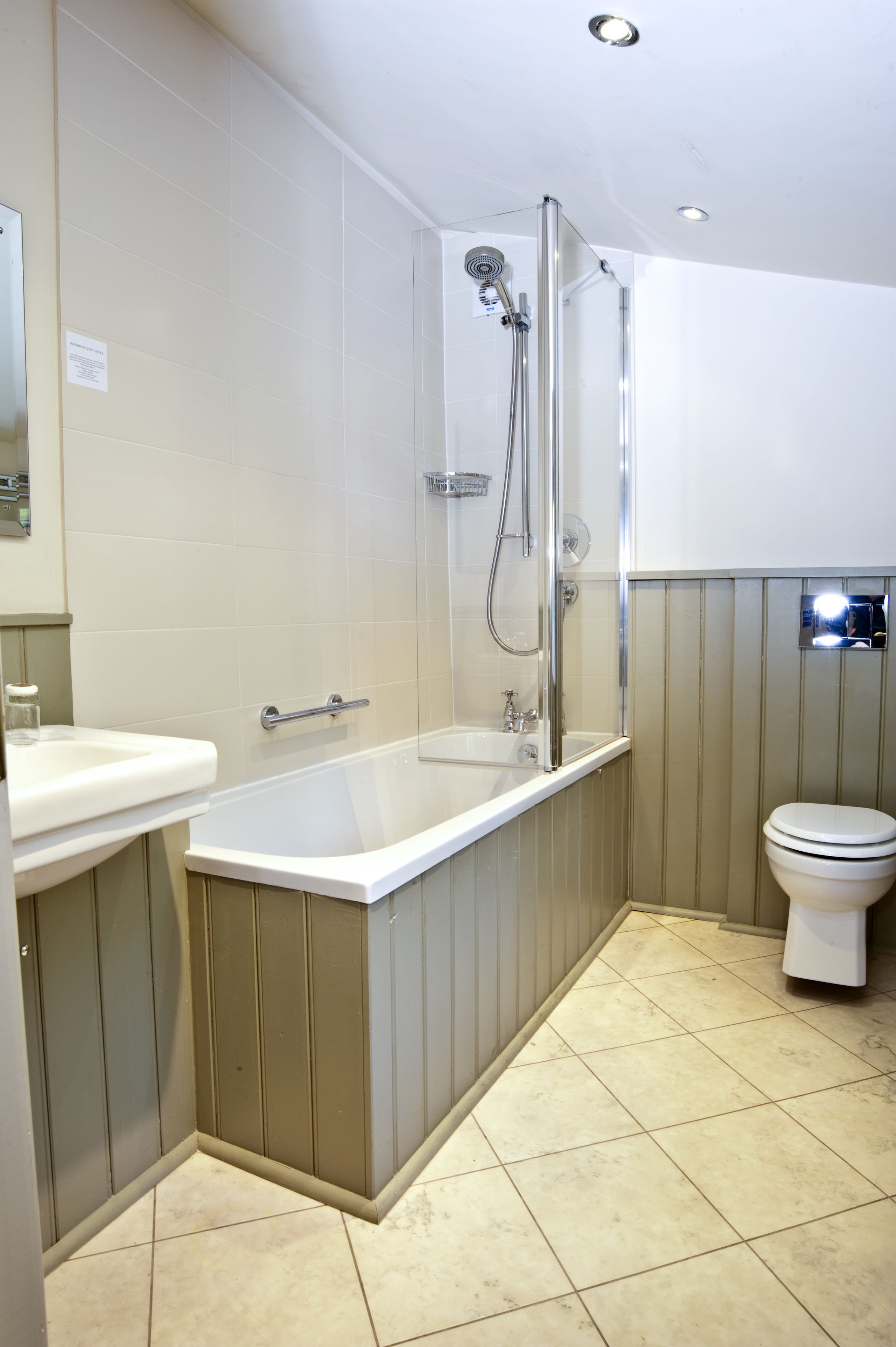Un baño moderno con ducha envuelta en vidrio, una bañera independiente y un inodoro.
